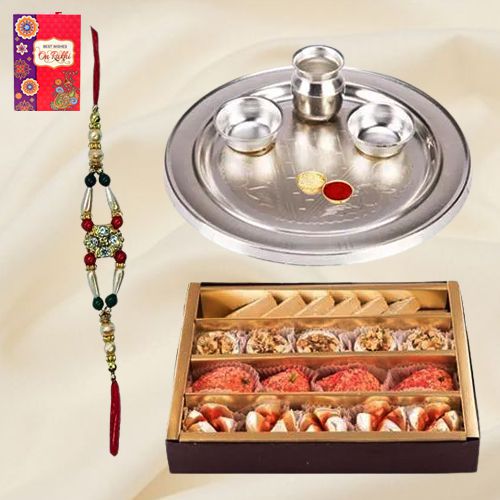 Assorted Sweets and Stylish and Trendy looking Silver Plated Paan Shaped Puja Aarti Thali along Rakhi, Roli, Tilak and Chawal Assorted Sweets and Stylish and Trendy looking Silver Plated Paan Shaped Puja Aarti Thali along Rakhi, Roli, Tilak and Chawal